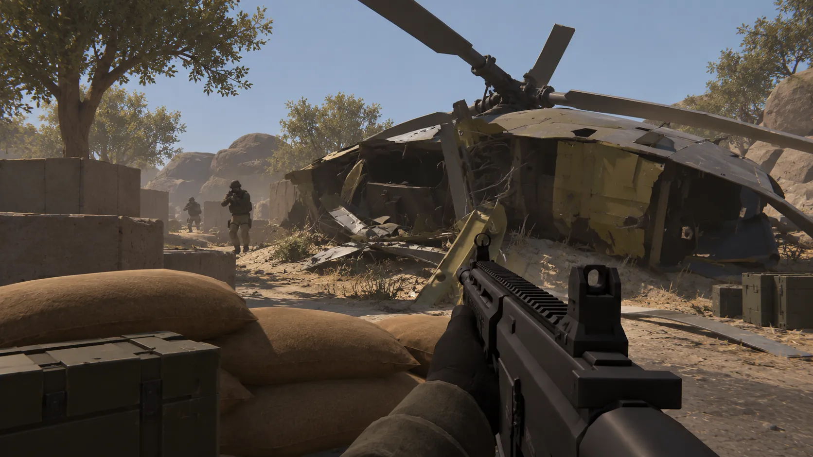 First-person view from behind sandbags at a desert defensive position, with a downed helicopter and approaching figures.
